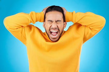 Image showing Angry, man and face with screaming in studio with burnout, anxiety and stress. Isolated, blue background and frustrated by problem with male person yelling and mental health from mistake and issue