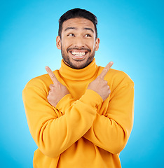 Image showing Happy, asian man and hands pointing in studio for choice, deal or sign up decision on blue background. Smile, direction and Japanese guy with recommendation, suggestion or coming soon launch platform