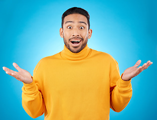 Image showing Wow, portrait and asian man in studio with hands for choice, decision or questions on blue background. Palm, scale and face of male customer confused, asking or why emoji for choosing, option or deal