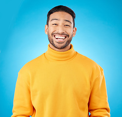 Image showing Laugh, portrait and happy asian man in studio with humor, joke or funny smile reaction on blue background. Comedy, face and Japanese guy model, free emotion or good mood, vibes or positive attitude