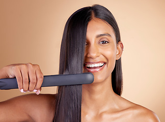 Image showing Portrait, hair and flat iron with a model woman in studio on a beige background for beauty or style. Face, smile and haircare with happy young female using a straightener appliance for natural care