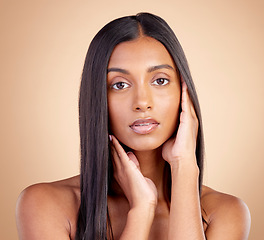 Image showing Portrait, hair care and Indian woman with cosmetics, makeup and skincare on a brown studio background. Face, female person and model with volume, texture and scalp treatment with natural beauty