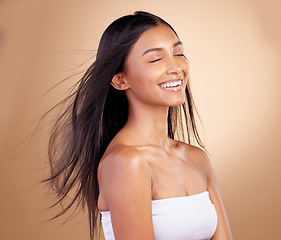 Image showing Salon, hairstyle and indian woman with beauty or wind in brown studio background. Happy, girl and haircare with eyes closed or keratin treatment for shine or volume and natural cosmetics with glow.