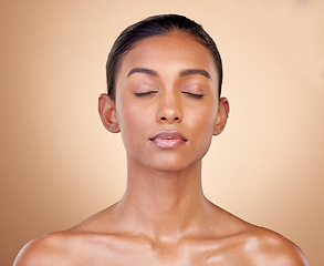 Image showing Skincare, beauty and Indian woman with cosmetics, facial and dermatology against a brown studio background. Female person, aesthetic and model with treatment, bare and shine with glow and wellness