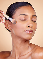 Image showing Beauty, makeup and foundation with woman and brush in studio for facial, relax and self care. Cosmetics, product and tools with face of model on brown background for glow, skincare and dermatology