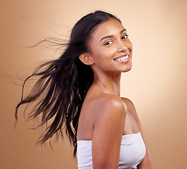 Image showing Portrait, haircare and salon for indian woman with beauty in brown studio background with glow. Hairstyle, happy face and girl with shine or keratin treatment, volume and natural cosmetic in mockup.