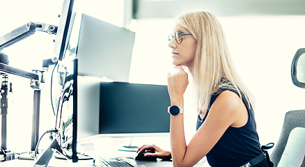Image showing Female financial assets manager, trading online, watching charts and data analyses on multiple computer screens. Modern corporate business woman concept.
