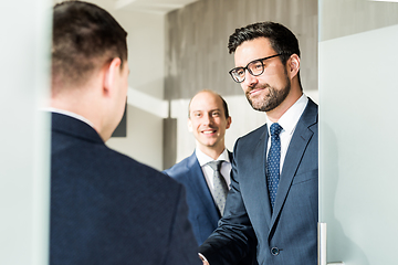 Image showing Group of confident business people greeting with a handshake at business meeting in modern office or closing the deal agreement by shaking hands.