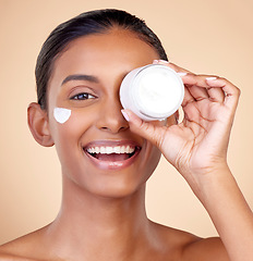 Image showing Woman, portrait and cream container of eye skincare, dermatology and cosmetics or self care. Facial product, happy face and young person or beauty model in skin care lotion on studio brown background