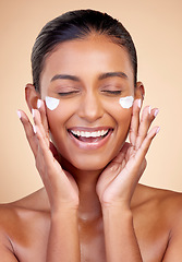 Image showing Cream, face and happy woman for beauty cosmetics, dermatology or aesthetic makeup on studio background. Indian female model, lotion and smile with facial sunscreen for clean skincare, glow and shine