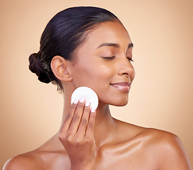 Image showing Woman, face and cotton pad, beauty and makeup removal, clean and natural skincare isolate on studio background. Indian female model, cosmetic product and cleaning facial, dermatology and skin glow