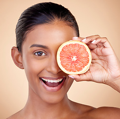 Image showing Happy woman, portrait and grapefruit, natural beauty and vitamin c with sustainable skincare on studio background. Face, female model and citrus fruit, eco friendly dermatology and cosmetic care