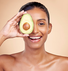 Image showing Avocado, skincare and portrait of happy woman in studio, background or aesthetic glow. Face of indian female model, natural beauty and fruit for sustainable cosmetics, healthy food or facial benefits
