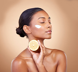 Image showing Woman, lemon and cream for natural skincare, beauty product and cosmetics or vitamin c benefits and thinking. Person sleeping with face lotion, fruits and skin dermatology on brown, studio background