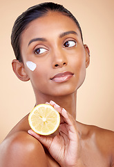 Image showing Woman, lemon and cream for skincare, natural beauty product and cosmetics or vitamin c benefits while thinking. Face sunscreen, fruits and young person for skin dermatology on studio brown background