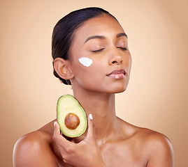 Image showing Beauty, cream and skincare with woman and avocado in studio for product, fruit and natural cosmetics. Spa, facial and lotion with face of model on brown background for vitamin c and self care