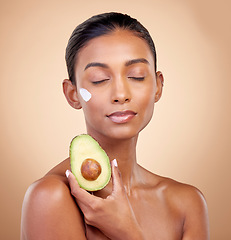 Image showing Avocado, cream and skincare with face of woman in studio for product, beauty and natural cosmetics. Spa, facial and lotion with female model on brown background for vitamin c, fruit and self care