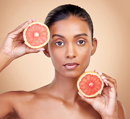 Image showing Grapefruit, portrait and skincare of woman in studio for vitamin c wellness, vegan cosmetics and dermatology. Face of indian female model, natural beauty and healthy citrus for facial aesthetic shine