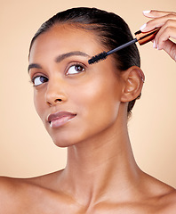 Image showing Face, mascara brush and woman, beauty and makeup with cosmetics tools isolated on studio background. Indian female model, cosmetology and skin glow, shine and eyelash extension with wellness