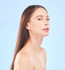 Image showing Portrait, beauty and hair with a model woman in studio on a blue background for skincare or keratin treatment. Spa, salon and haircare with a young female person posing for shampoo promotion