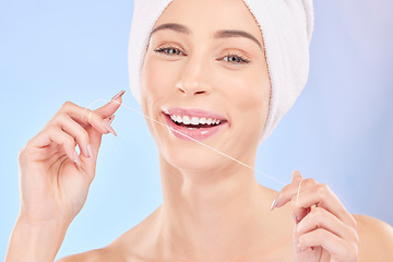 Image showing Flossing, teeth and woman in portrait, dental and health with oral care isolated on blue background. Female model, morning routine and orthodontics, hygiene and cleaning mouth with thread in studio