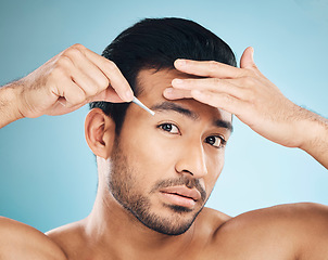 Image showing Man, face and eyebrow tweezers, beauty and skin, hair removal and cosmetics on blue background. Grooming, hygiene and male model, portrait and wellness with treatment, tools and self care in studio