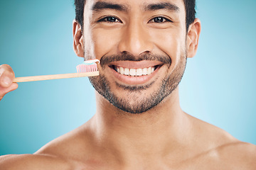 Image showing Dental, portrait and Asian man with a toothbrush, fresh breath and wellness against a blue studio background. Face, male person and happy model teeth whitening, mouth cleaning product and toothpaste