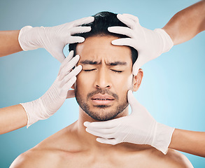 Image showing Face, hands and plastic surgery with a nervous man in studio on a blue background for beauty enhancement. Aesthetic, botox and change with a young male patient eyes closed in a clinic for skincare