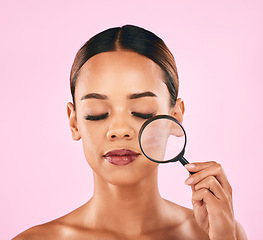 Image showing Woman, face and magnifying glass, beauty and zoom in on pores, skincare and makeup isolated on pink background. Search, investigate and check skin with glow, female model and dermatology in studio