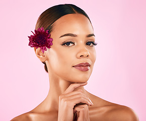 Image showing Skincare, beauty and portrait of woman with flower, makeup and organic glow on pink background. Cosmetics, natural dermatology and model with facial care, nature and healthy spa aesthetic in studio.