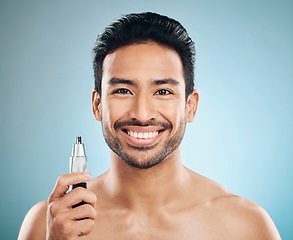 Image showing Hair removal, face and man with beauty and trimmer, smile and cosmetic care isolated on blue background. Happy male model, tools and shaving, grooming and hygiene with body maintenance in studio