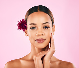 Image showing Skincare, cosmetics and portrait of woman with flower, makeup and wellness glow on pink background. Natural beauty, dermatology and model with luxury facial care and healthy spa aesthetic in studio.