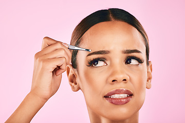 Image showing Pain, face and woman with tweezer for hair removal in studio isolated on a pink background. Beauty, facial and eyebrow plucking of model for self care, skincare and wellness, aesthetic and cosmetic