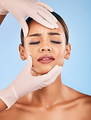 Image showing Plastic surgery, hands and woman in pain for skincare in studio isolated on a blue background. Beauty, dermatology or model with doctor for cosmetic transformation, aesthetic change or face treatment