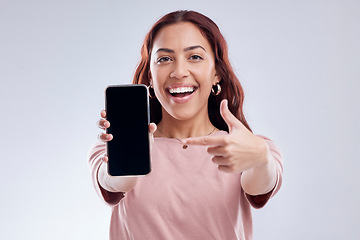 Image showing Happy woman is pointing at phone screen, mockup and marketing, mobile app ads on white background. Website promo, advertising and female ambassador in portrait with social media branding in studio