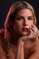 Image showing Portrait, beauty and lipstick with a model woman in studio on a dark background in red lighting for desire. Face, skincare or makeup with a young female person posing for natural feminine confidence