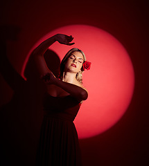 Image showing Vintage, creative and a woman in a spotlight on a studio background for an art aesthetic. Fashion, retro and a young girl or rich model in a stylish dress or clothes isolated on a red backdrop