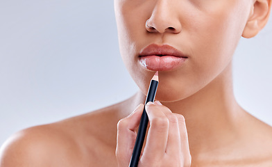 Image showing Makeup, mouth and woman with lip pencil in studio for beauty, cosmetics and color on grey background. Liner, filling and hand of female model with beauty product for glamour, routine or application