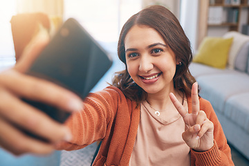 Image showing Face, woman and peace for selfie with smile in home while live streaming on video call in living room. Profile picture, happy female gen z and show v sign, hand emoji and memory for social media post