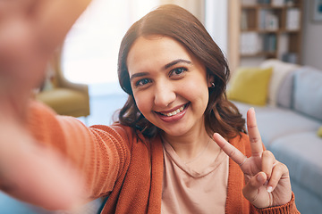 Image showing Portrait, woman and peace for selfie in home, smile and fun with live streaming vlog in living room. Face, profile picture and happy female gen z show v sign, hand emoji and memory for social media