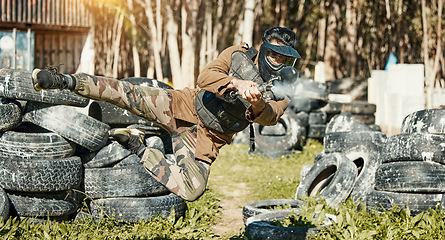 Image showing Paintball, sports and man in action with gun for tournament, competition and battle in nature. Camouflage, military and male person shooting in outdoor arena for training, adventure game or challenge