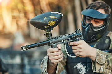 Image showing Paintball, sports and man shooting with gun for tournament, competition and battle in nature. Soldier, military and male person in outdoor arena for training, adventure games and challenge for action