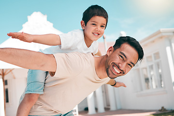 Image showing Happy, airplane and portrait of a father with his child in the outdoor garden at their family home. Playful, smile and young dad carrying his boy kid on his back while bonding and playing together.