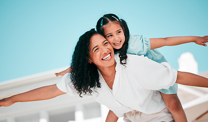 Image showing Smile, airplane and mother with her child in the outdoor garden at their family home for adventure. Playful, happy and young mom carrying her girl kid on her back while bonding and playing together.