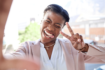 Image showing Happy black woman, peace sign and selfie in city with tongue out for photograph, memory or vlog outdoors. Face of female person or employee smile for fun picture, humor or happiness in an urban town