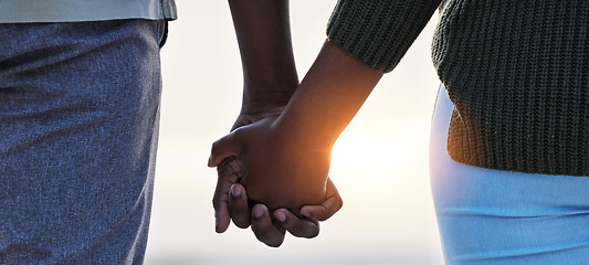 Image showing Holding hands, couple and love outdoor at the beach with care, trust and commitment. Closeup of a man and woman relax together on vacation, holiday or sunset travel adventure in nature for freedom