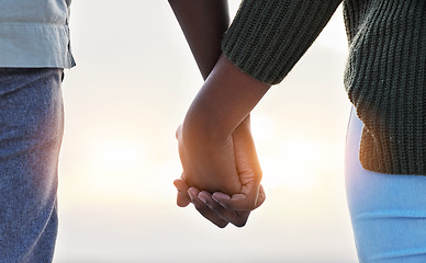 Image showing Couple, holding hands and together outdoor at the beach with love, care and commitment. Closeup of a man and woman on vacation, holiday or sunset travel adventure in nature with support and trust