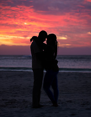 Image showing Couple, sunset and silhouette outdoor at the beach with love, care and commitment. Romantic man and woman hug or affectionate on vacation, holiday or nature travel adventure with sunrise sky on date