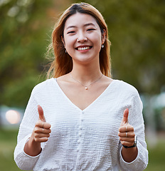 Image showing Thumbs up, happy and portrait of Asian woman in park for support, relaxing and happiness outdoors. Smile, nature and face of female person with hand gesture for agreement, thank you and yes sign