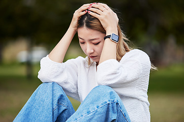 Image showing Sad, depression and a woman in a park with a mental health problem, thinking and anxiety. Tired, idea and a girl or person in a garden or field with fear, anger or depressed about a mistake or fail